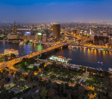 Panoramic view of Cairo cityscape and Nile River at dusk.