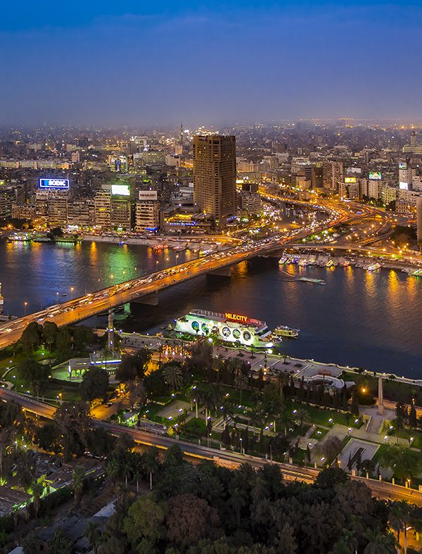 Panoramic view of Cairo cityscape and Nile River at dusk.