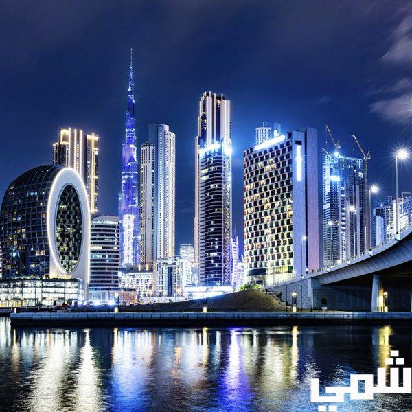 Dubai skyline at night with illuminated skyscrapers and bridge.